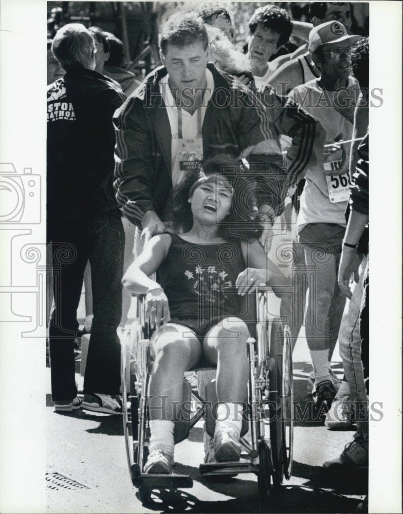 1989 Press Photo Boston Marathon Runner Put In Wheelchair After Finishing - Historic Images