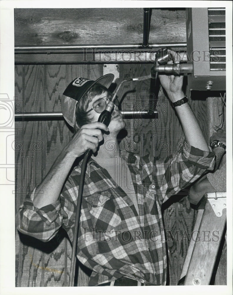 1980 Press Photo Steve Johnson Works On Water Pipe At Education Center - Historic Images