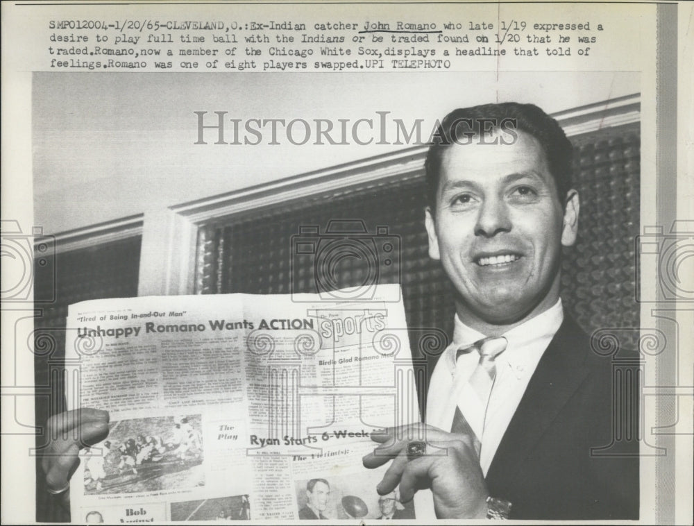 1965 John Romano holds up newspaper of news that he was traded - Historic Images