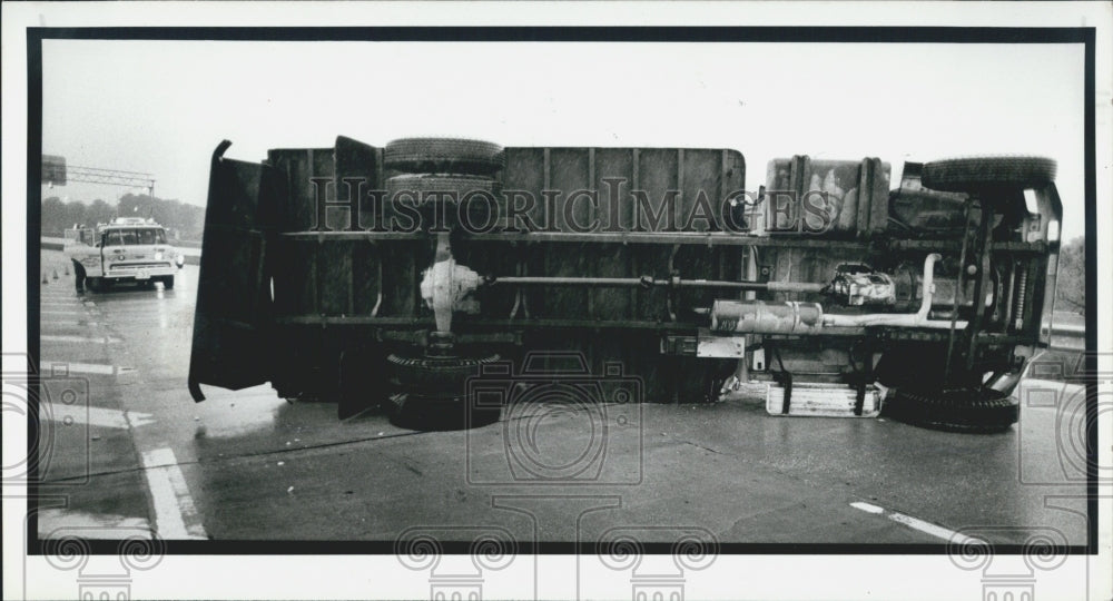 1987 Press Photo Truck tipped over during heavy rain on ramp from Gandy Blvd. - Historic Images