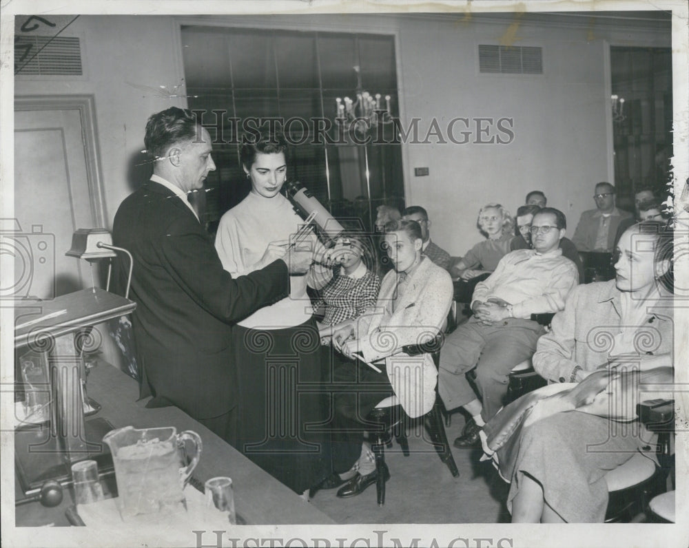 1957 Rodrey J. Faxon shows Molly Gaba how scope works. - Historic Images