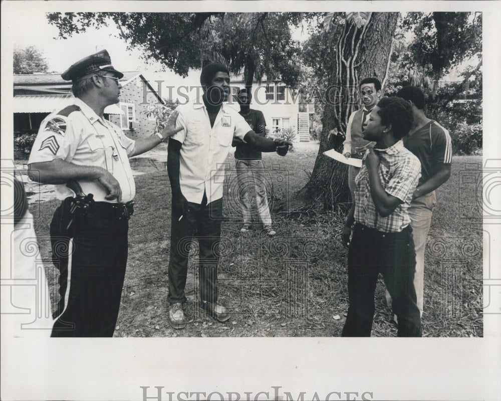 1980 Press Photo A police officer questions bystanders after the incident occure - Historic Images