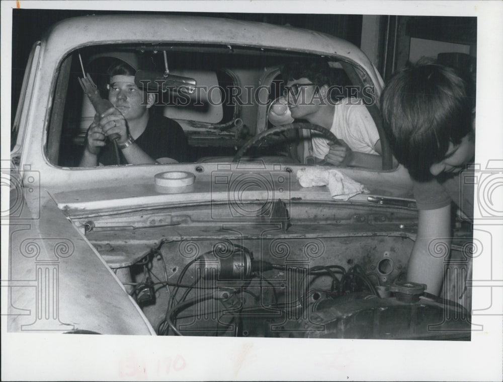 1971 Gary Butters and Dean Cate work on the English Ford - Historic Images