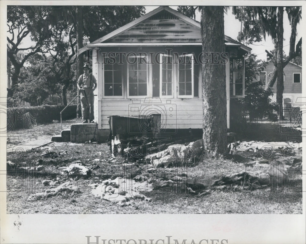 1966 A fireman looks out for a Fire-Damaged house. - Historic Images