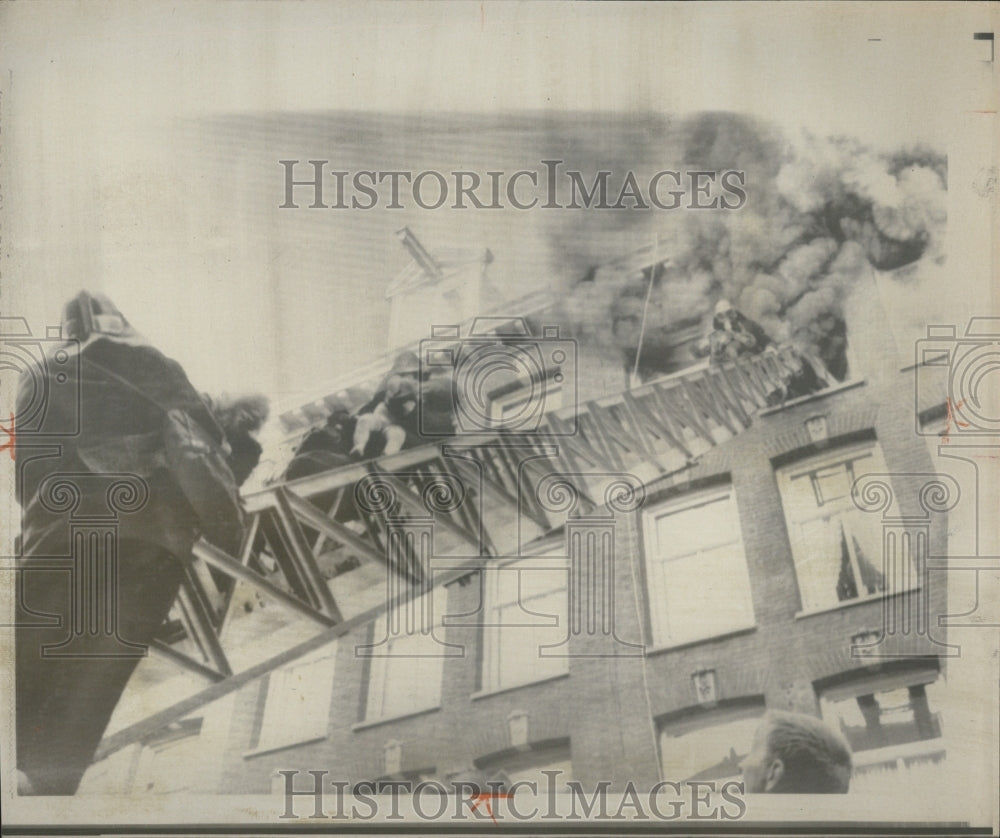 1966 Fireman carry four children from their blazing apartment - Historic Images
