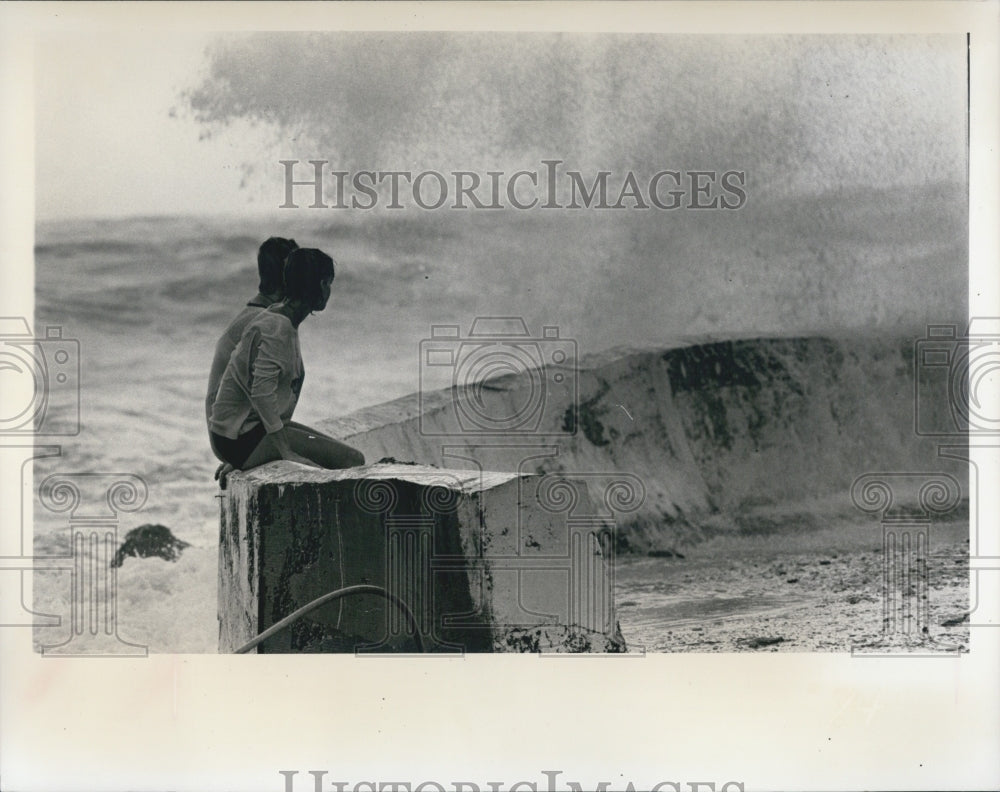 1975 Girls Sit Atop Seawall and Watch the Waves - Historic Images