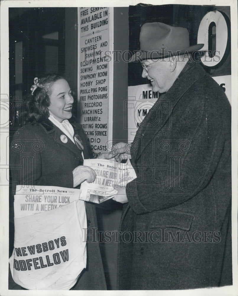 1945 George W. Stark buys a paper from Bernice Becker. - Historic Images