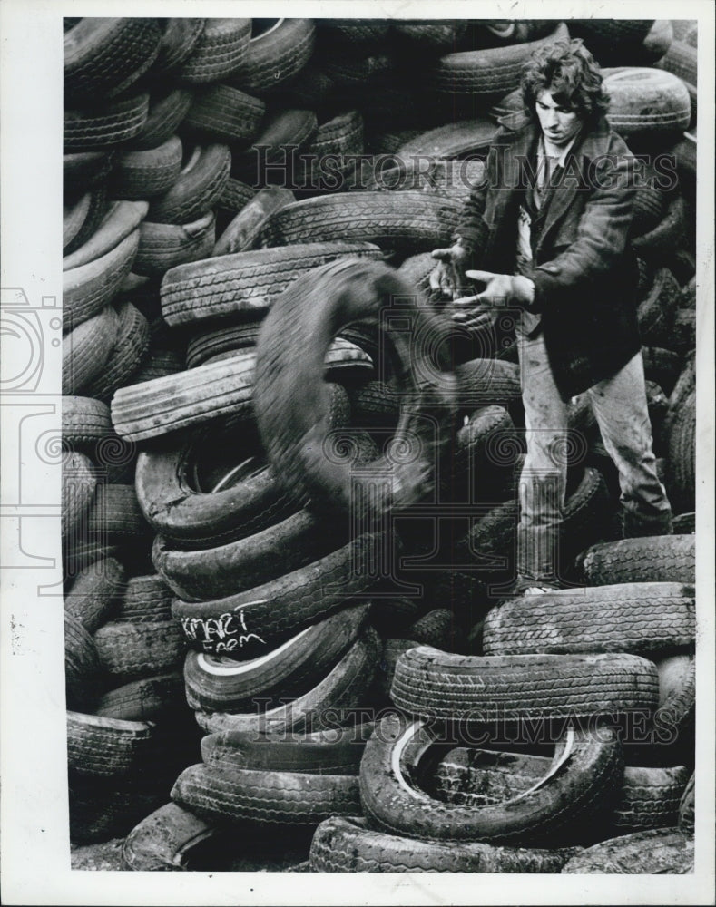 1983 Press Photo man throws tires pile - Historic Images