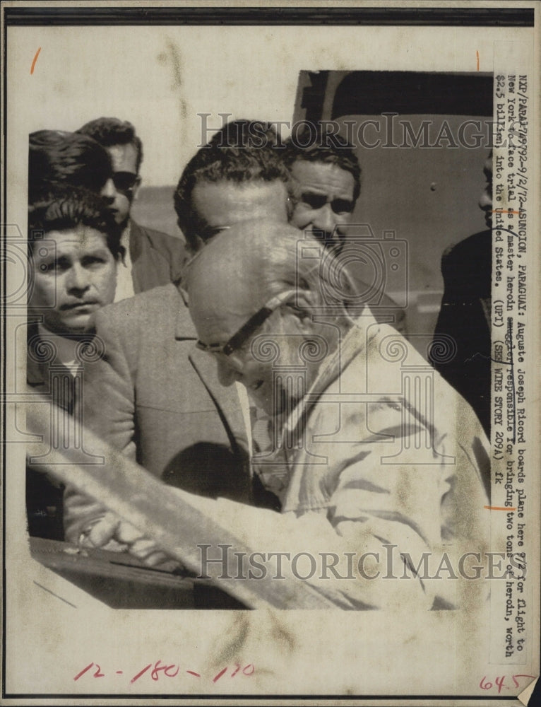 1972 Auguste Joseph Ricord boards plane to New York to face charges. - Historic Images