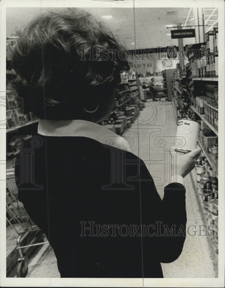 1975 Store buyer reading nutritional facts. - Historic Images