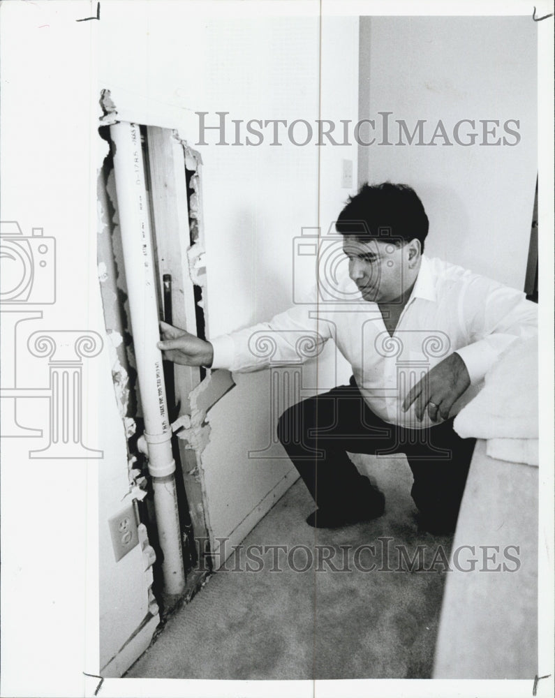 1991 Press Photo Richard Pillina Examines the wall which gas is leaking. - Historic Images