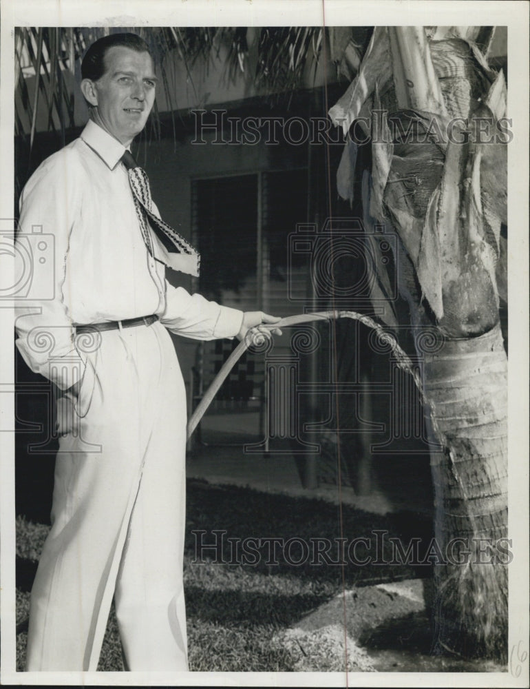 Press Photo Marty MaGee waters a palm tree - Historic Images