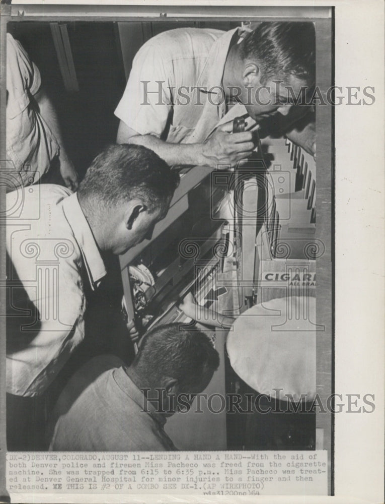 1964 Miss Pacheco and police and firemen free her from cigarette - Historic Images