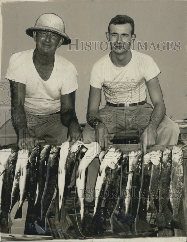 1946 Leon Walsh and Donald Preston showing the size of trout string caught. - Historic Images