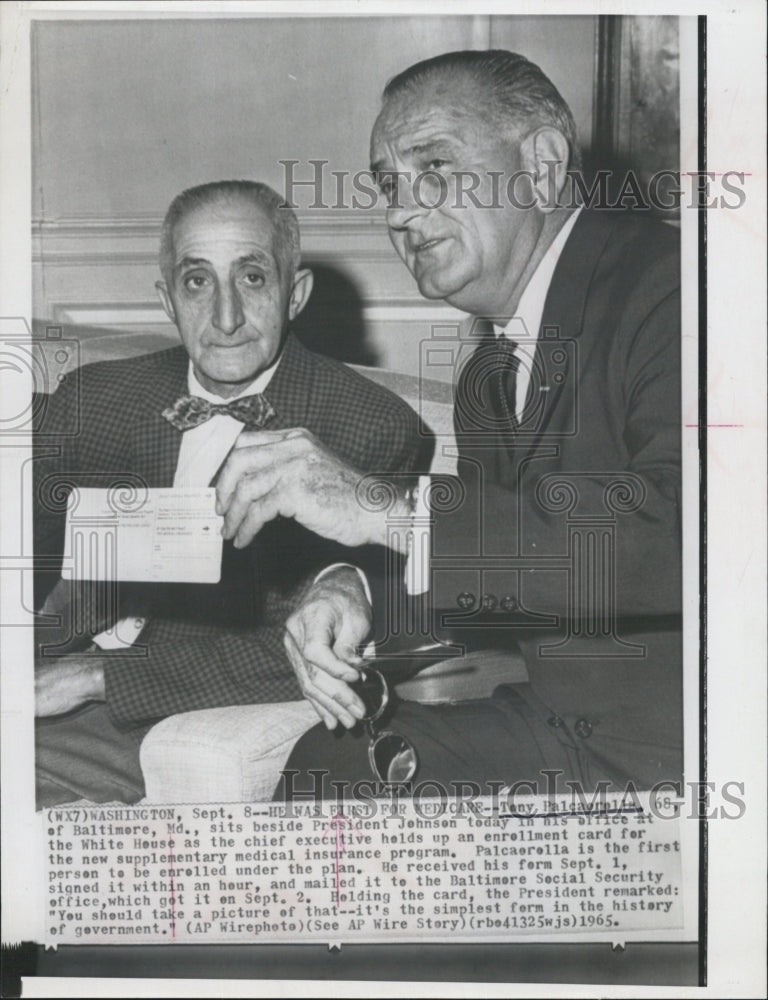 1965 Press Photo President Johnson holds card for medical insurance. - RSG66089 - Historic Images