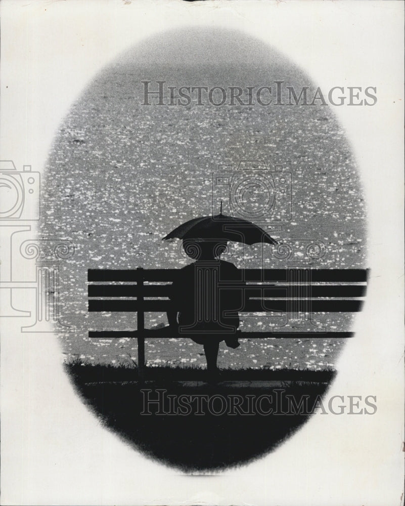 1973 Press Photo Person Sitting By The Water Holding An Umbrella - RSG68225 - Historic Images