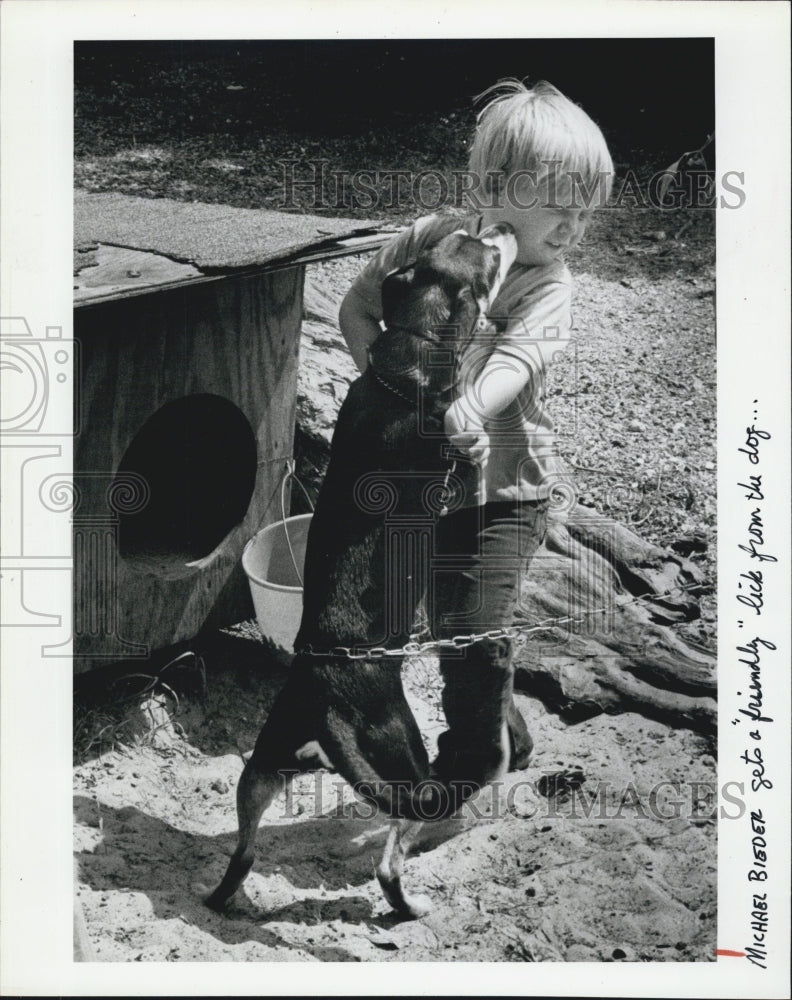 1981 Press Photo Michael Bieder gets a "friendly lick" from a puppy - Historic Images