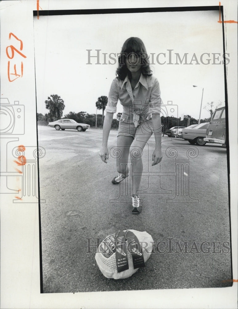 1974 lady picking a Turkey. - Historic Images