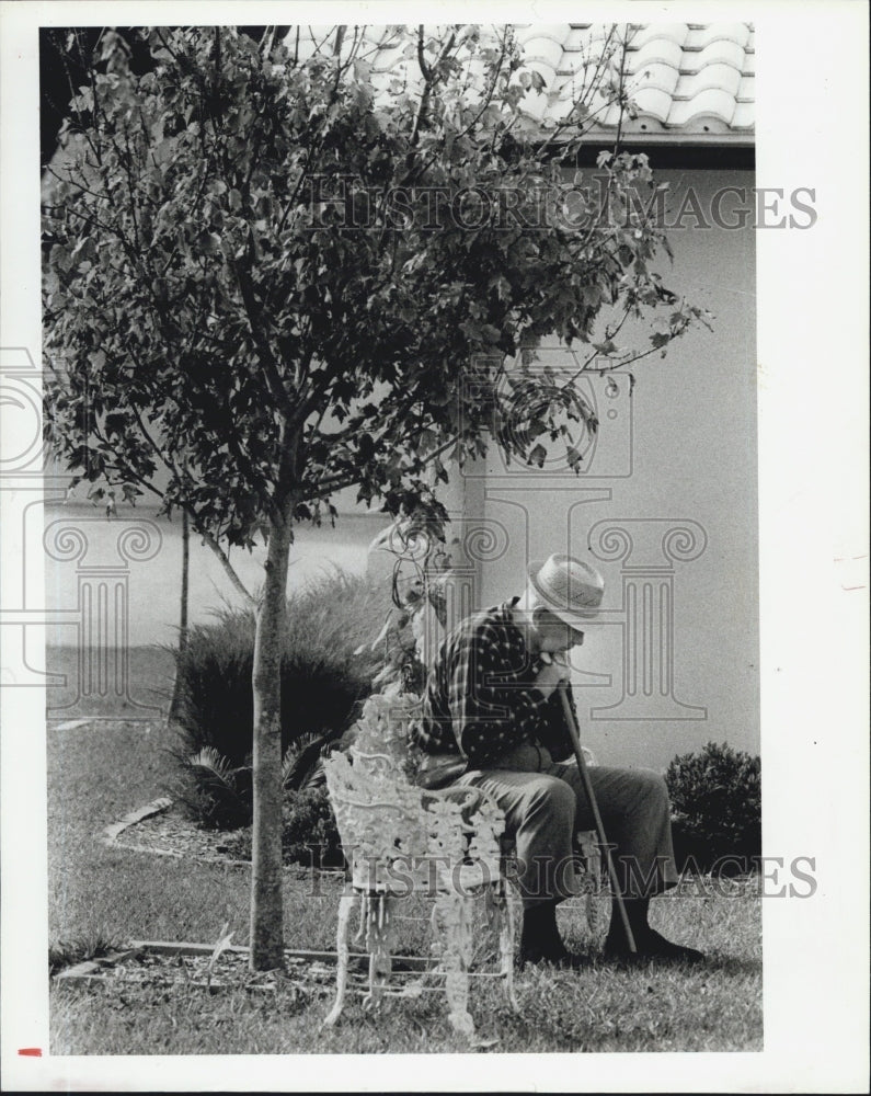 1984 Press Photo Mitchell Czopek Sits In His Backyard Of His Orchid Lake Home - Historic Images