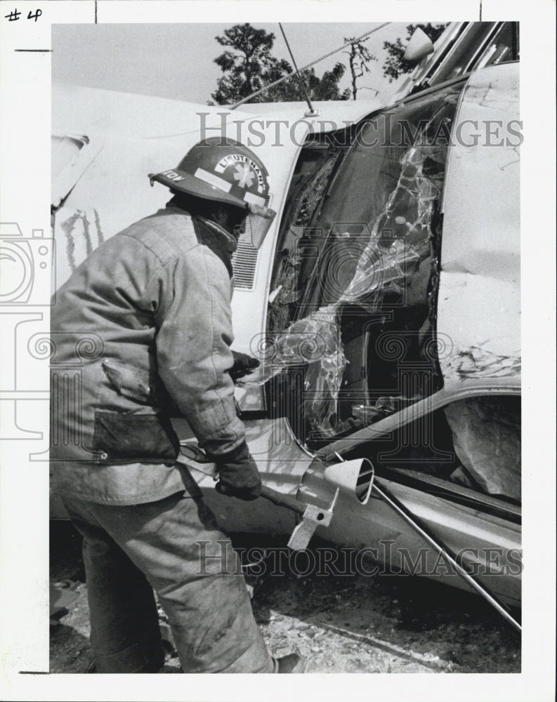 1987 Press Photo Lt .John Dixon of Pinellas uses a Pry-ax to remove windshield. - Historic Images