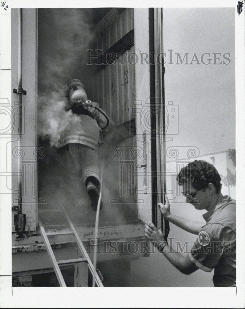 1988 Press Photo Firefighter open the door to the smoke-filled semitrailer. - Historic Images