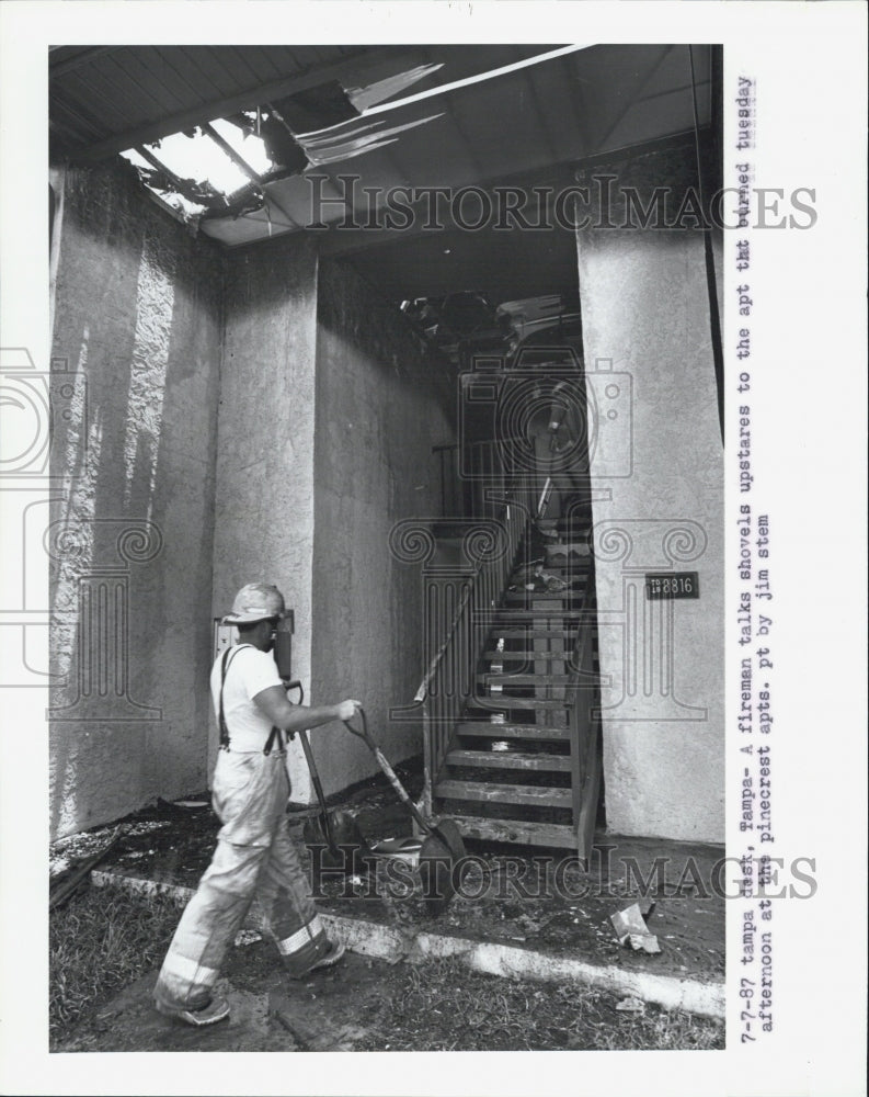 1987 Press Photo Firemen walks with shovel at Pinecrest Apartments. - Historic Images
