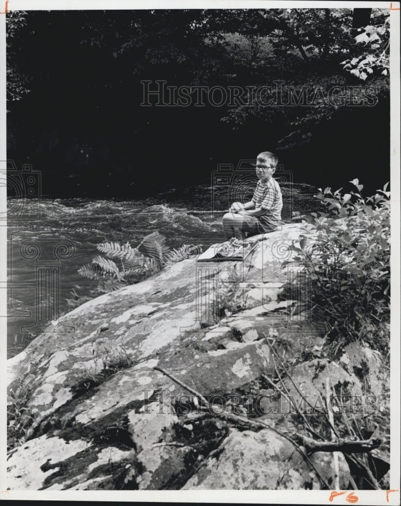 1975 Joe Hall beside a river near his home - Historic Images