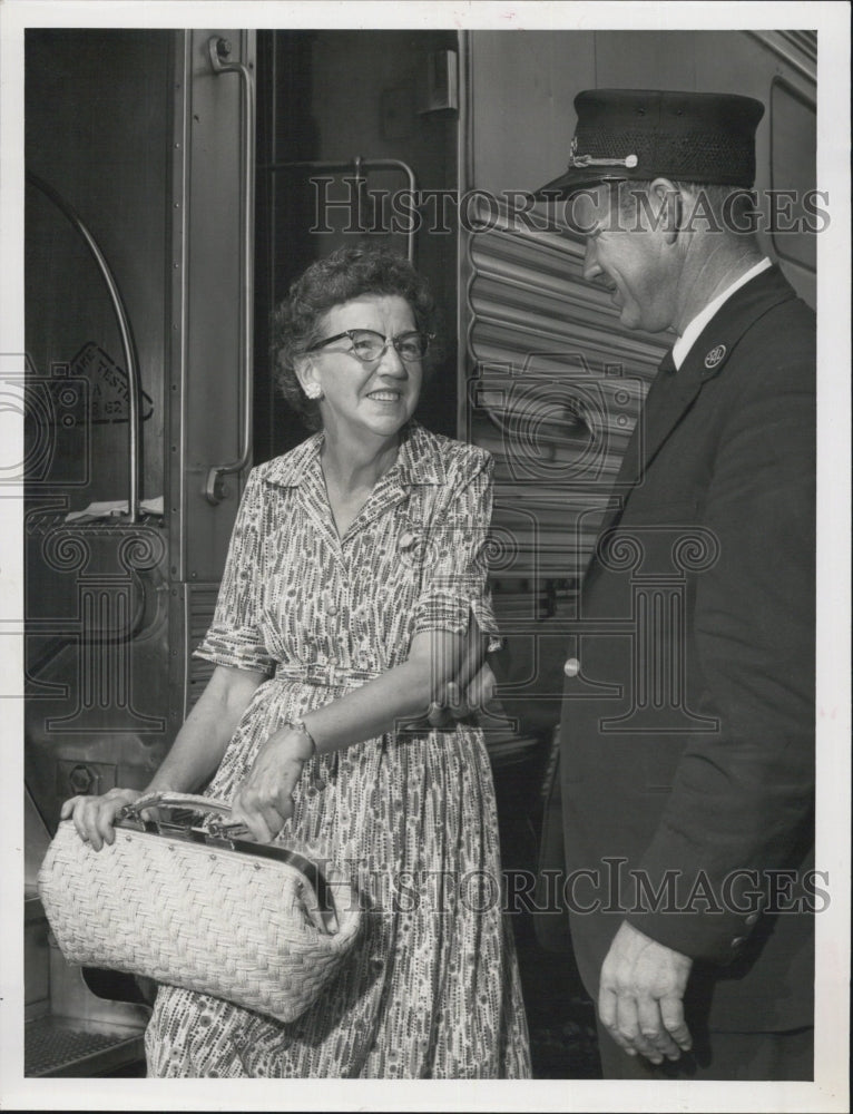 1962 Mrs. Catherine Pascale smiles at trainman P.Q. Weimer - Historic Images