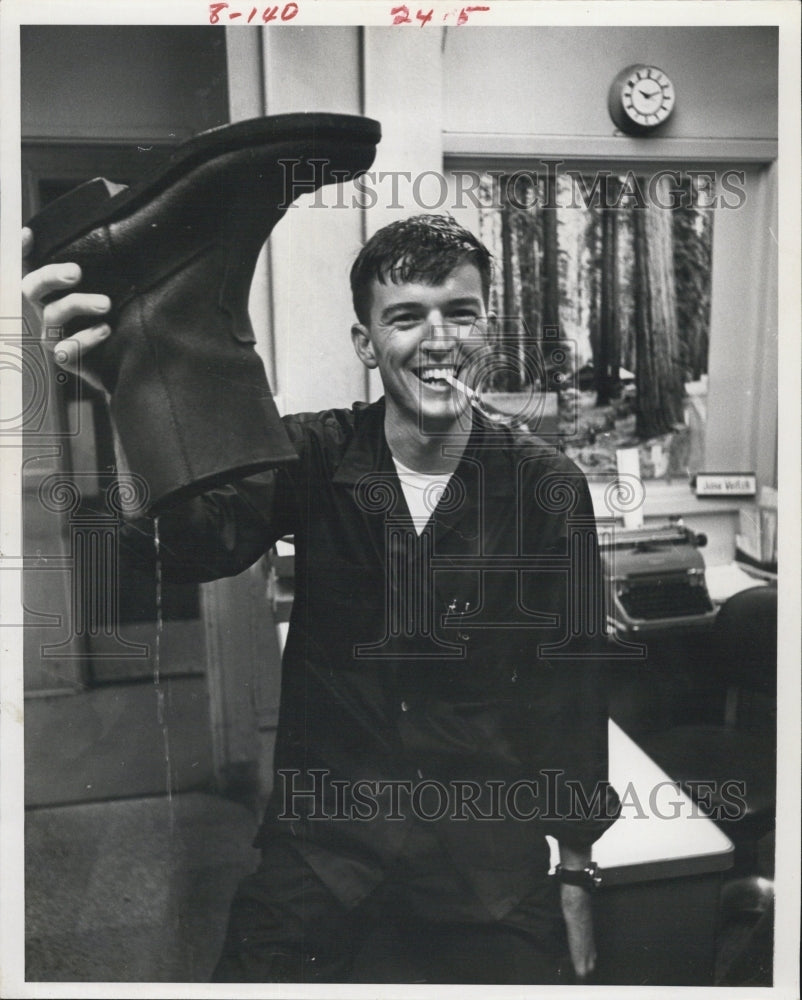 Press Photo A Man holding a boot - Historic Images