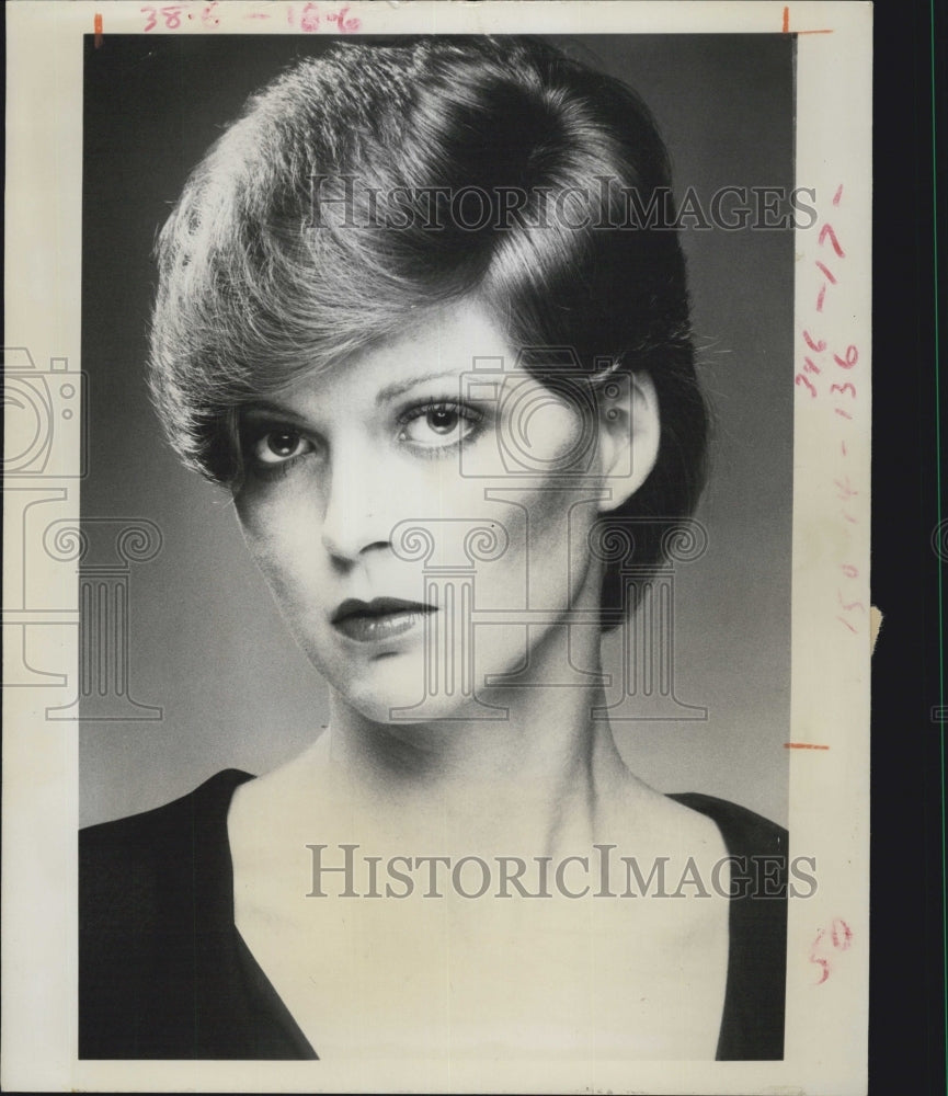 1976 A woman models a sculptured coiffure with a side part. - Historic Images