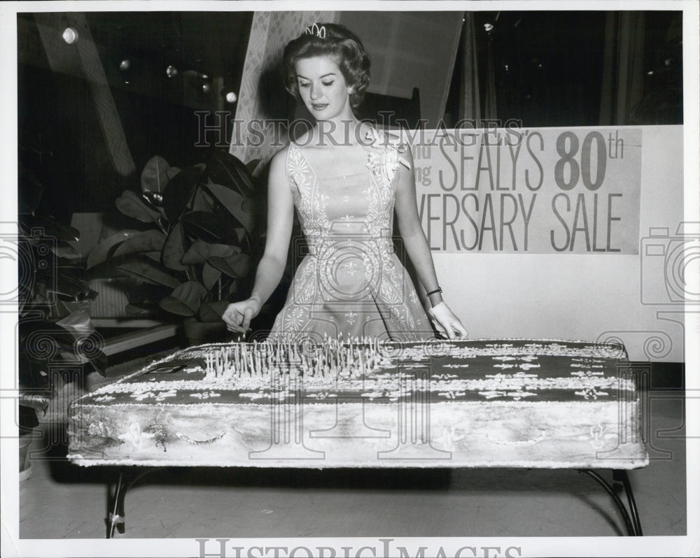 1961 Charlene Lee is holding a candle to a cake shaped like a - Historic Images