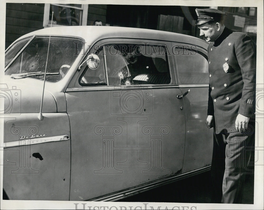 1957 Press Photo Officer Francis Hegner looks over car found with 3 bullets - Historic Images