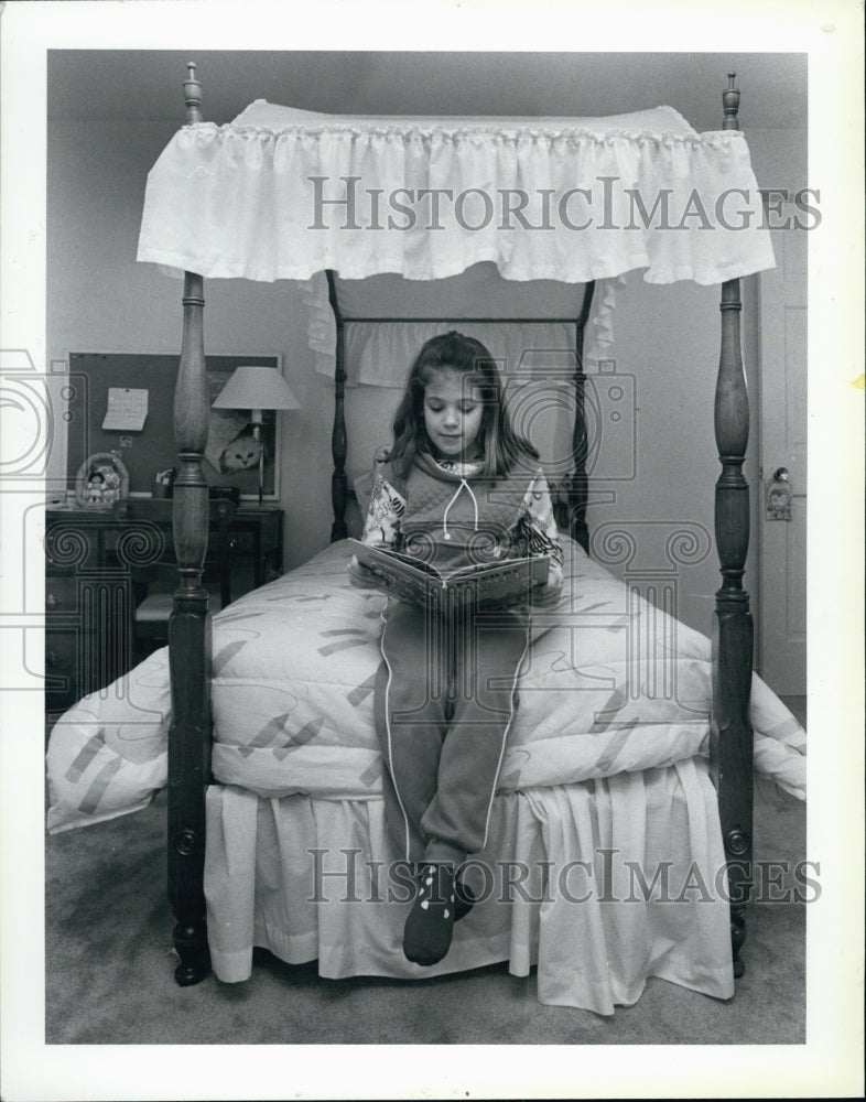 1986 Press Photo Beth Fernino Reads Book Canopy Bed - Historic Images