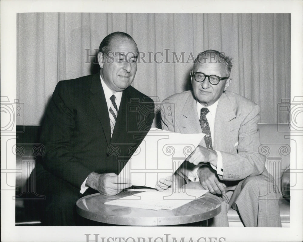 1957 Press Photo A picture of A.M Sonnabend(L) receives a report with Atty.Engel - Historic Images