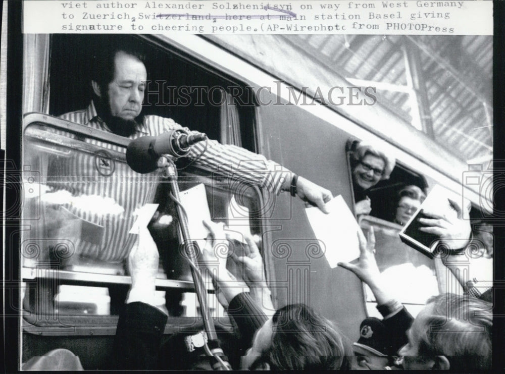 1974 Alexander Solshenitsyri giving signature to cheering people - Historic Images