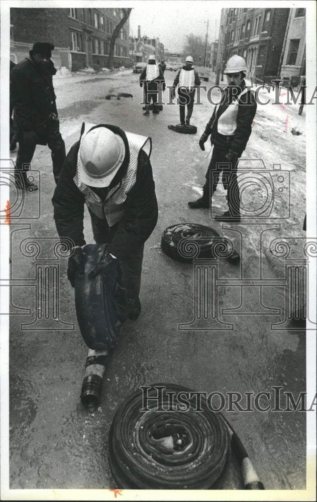 1980 Press Photo Streets and Sanitation men roll up hoses which were used - Historic Images