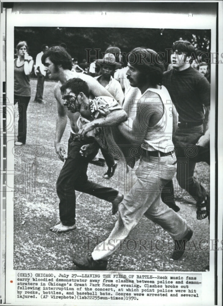 1970 Press Photo Rock Music Fans Carry Bloodied Demonstrator Away From Clashes - Historic Images