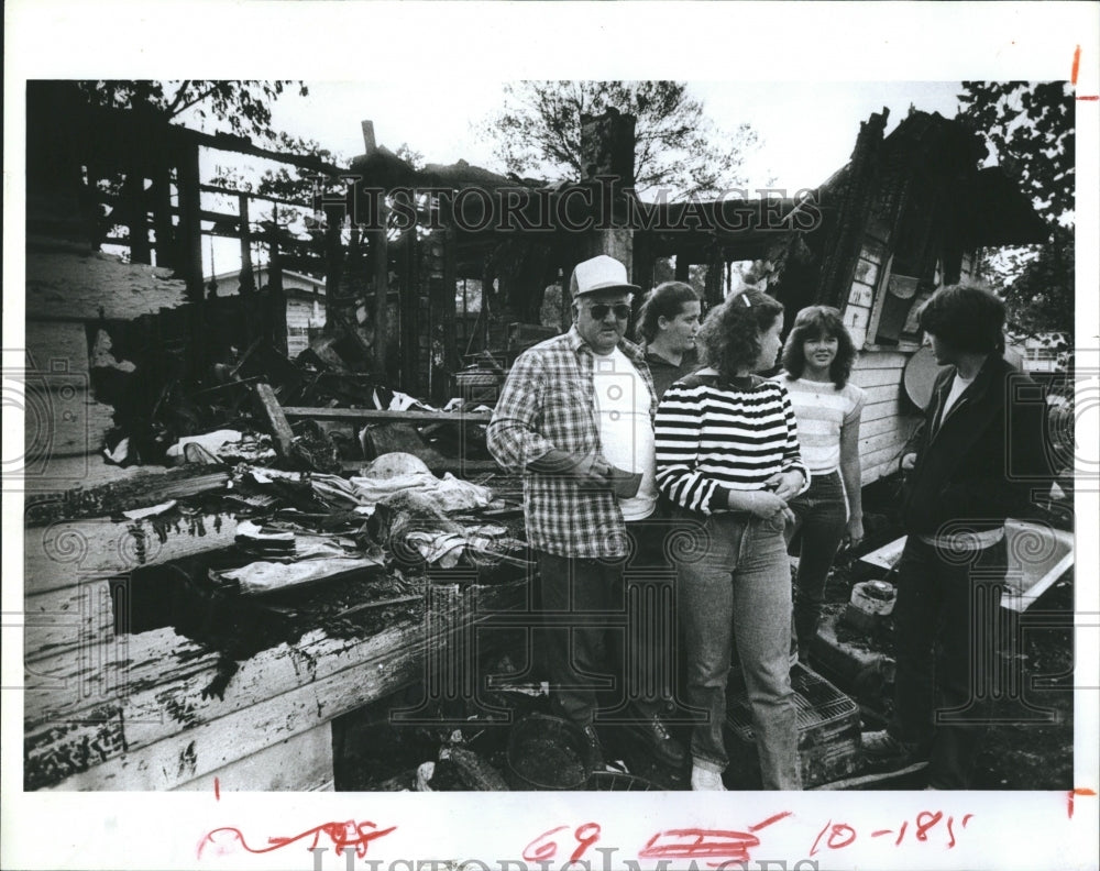 1983 Press Photo Hank Beals stands by remains of home with Wife &amp; Children - Historic Images