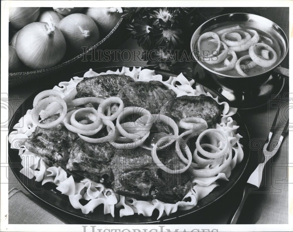 1985 Press Photo Onions In Creamy Curry Sauce Top Pork Chops IN Skillet Entree - Historic Images