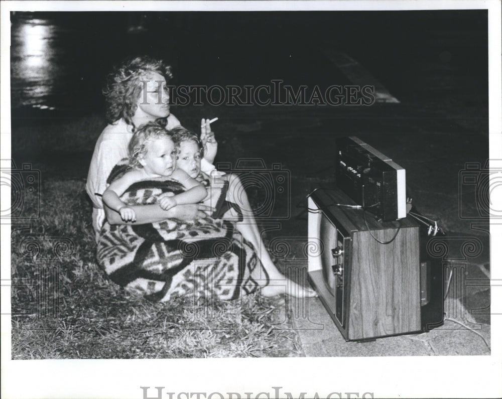 1985 Press Photo Residents of the Holiday Motel sit outside watching the fire - Historic Images