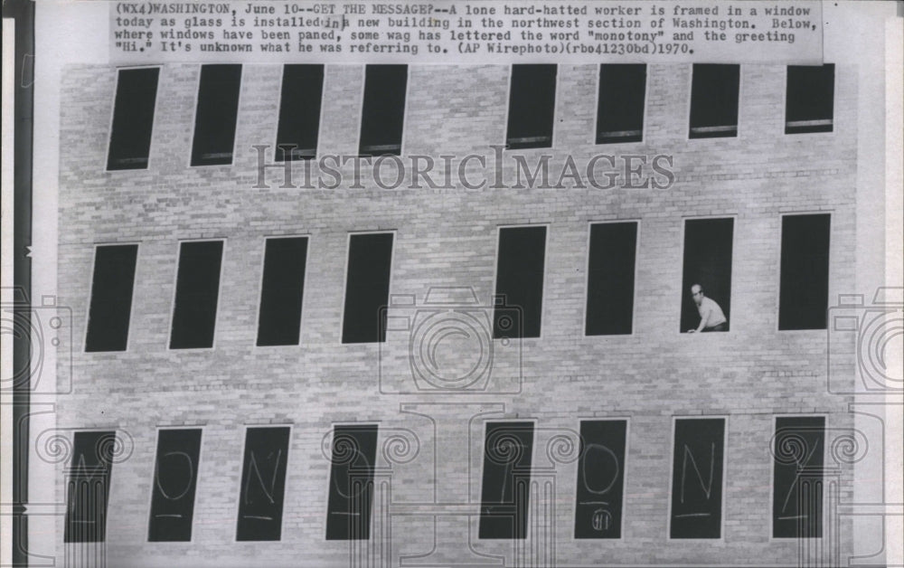 1970 Press Photo A worker installs glass into a new building in Washington. - Historic Images