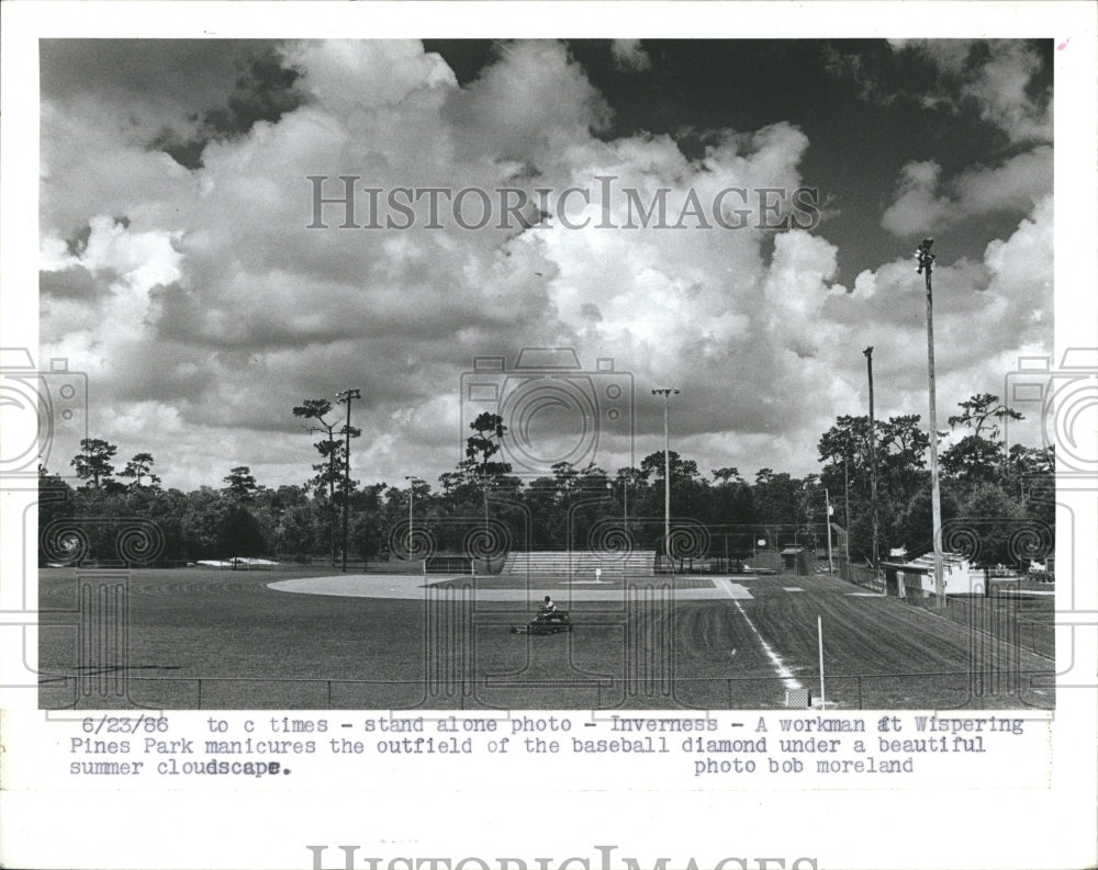 1986 Press Photo Workman Mows Lawn At Whispering Pines Baseball Diamond Park - Historic Images
