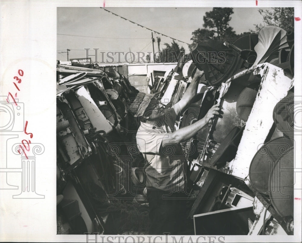 1966 Press Photo Appliance doctor Peter Watson checks a washer for spare parts. - Historic Images