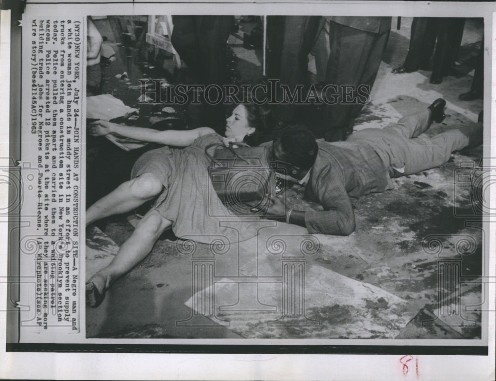 1963 Press Photo Black man and white woman join hands in effort to block street - Historic Images