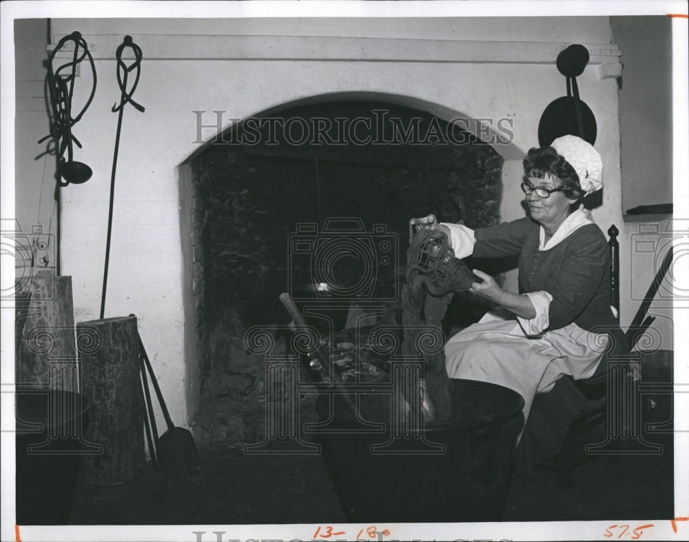 Press Photo woman sits beside fire place. - Historic Images