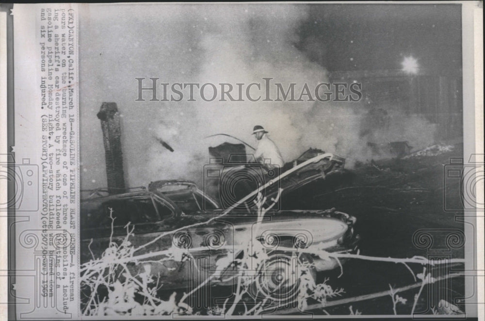 1969 Press Photo Fireman pours water on burning wreckge - RSH15525 - Historic Images