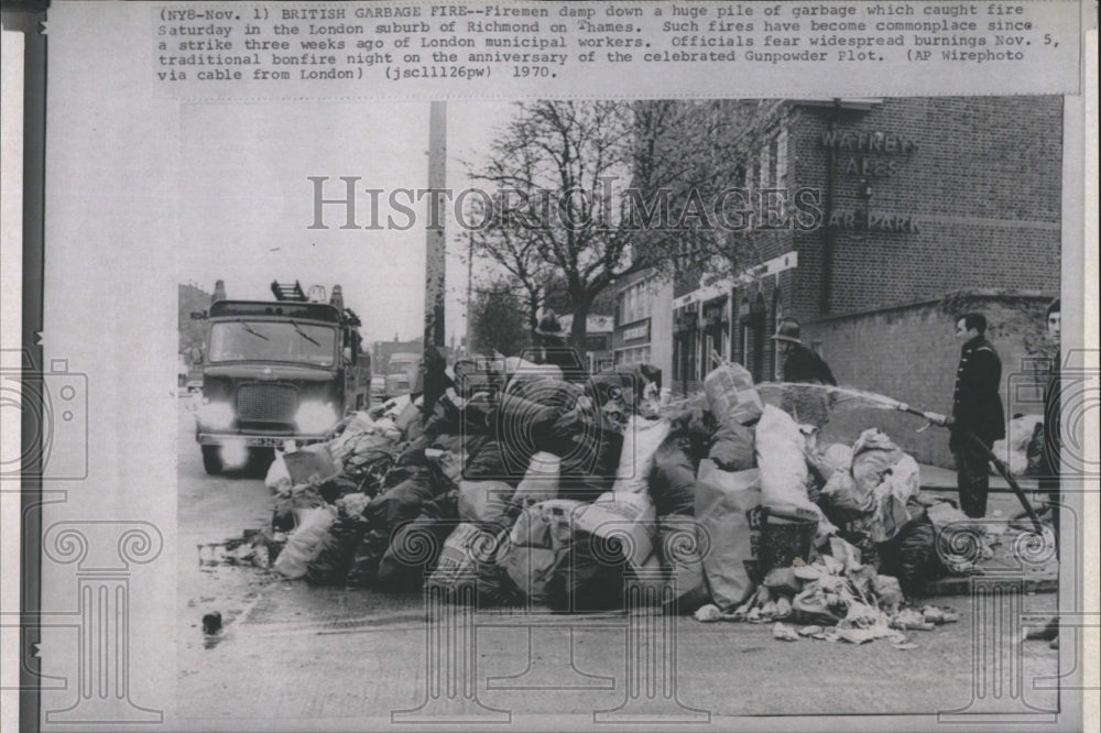 1970 Press Photo Firemen Hose Down Pile of Flaming Garbage - Historic Images