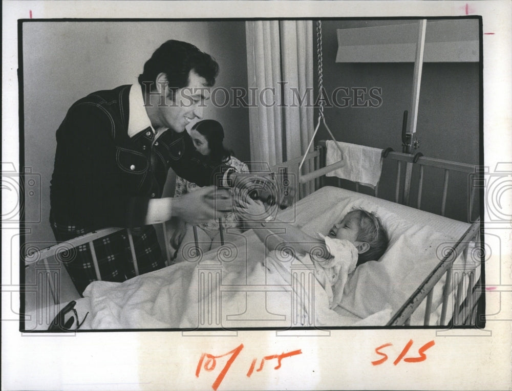 1974 Press Photo Fred Holiday TV Host, Give gold Ball to a young Patient. - Historic Images