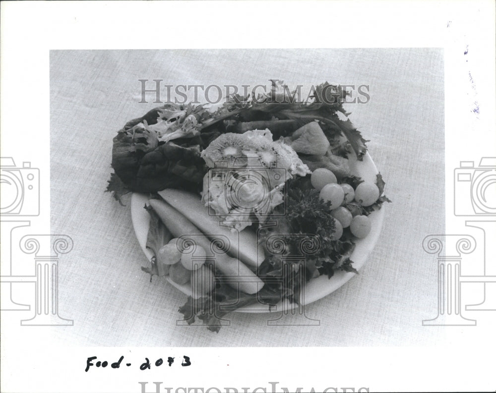 1985 Press Photo Kiwis adorn the top of this fruit and greens salad. - Historic Images