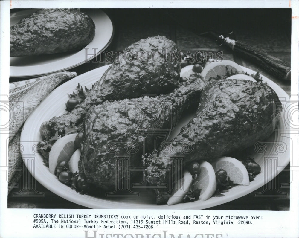 1985 Pictured is a dish of cranberry relish turkey drumsticks.-Historic Images